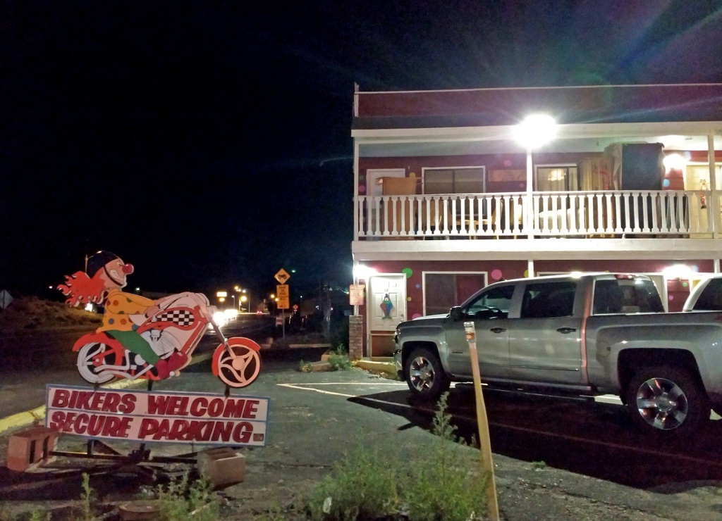 A sign "bikers welcome" with a clown riding a motorcycle in front of the drive up old style roadside motel