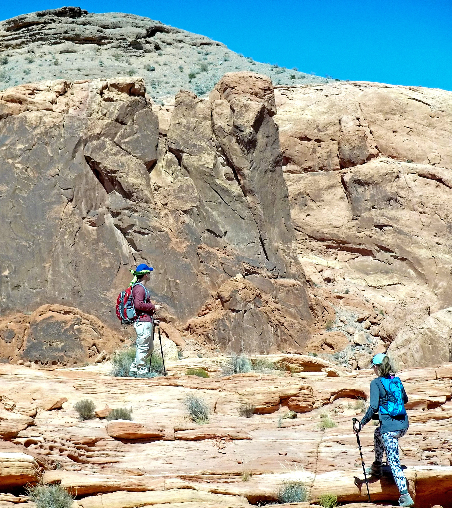 A man and woman with hiking poles and backpacks